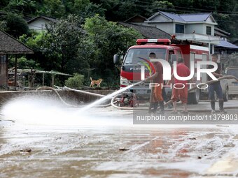 Firefighters are washing a road in Si 'an village, Rongan county, Liuzhou city, South China's Guangxi Zhuang Autonomous region, in Liuzhou,...