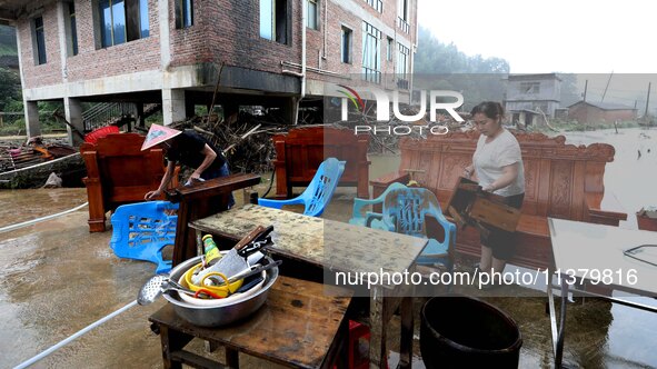 Villagers are moving furniture soaked by floods in Si 'an village, Rongan county, Liuzhou city, South China's Guangxi Zhuang Autonomous regi...