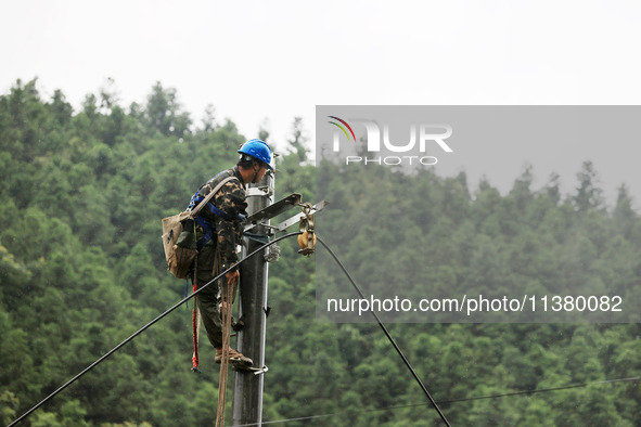 Electric power workers are repairing a power supply line at a pole in Si'an village, Rongan county, Liuzhou city, South China's Guangxi Zhua...