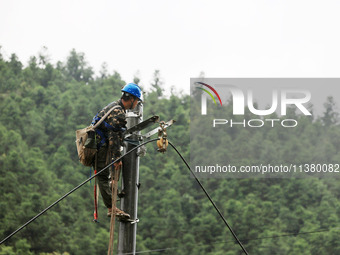 Electric power workers are repairing a power supply line at a pole in Si'an village, Rongan county, Liuzhou city, South China's Guangxi Zhua...