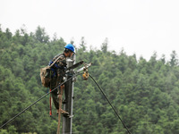 Electric power workers are repairing a power supply line at a pole in Si'an village, Rongan county, Liuzhou city, South China's Guangxi Zhua...