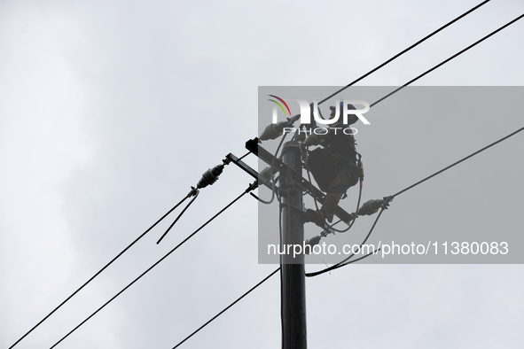 Electric power workers are repairing a power supply line at a pole in Si'an village, Rongan county, Liuzhou city, South China's Guangxi Zhua...