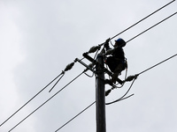 Electric power workers are repairing a power supply line at a pole in Si'an village, Rongan county, Liuzhou city, South China's Guangxi Zhua...