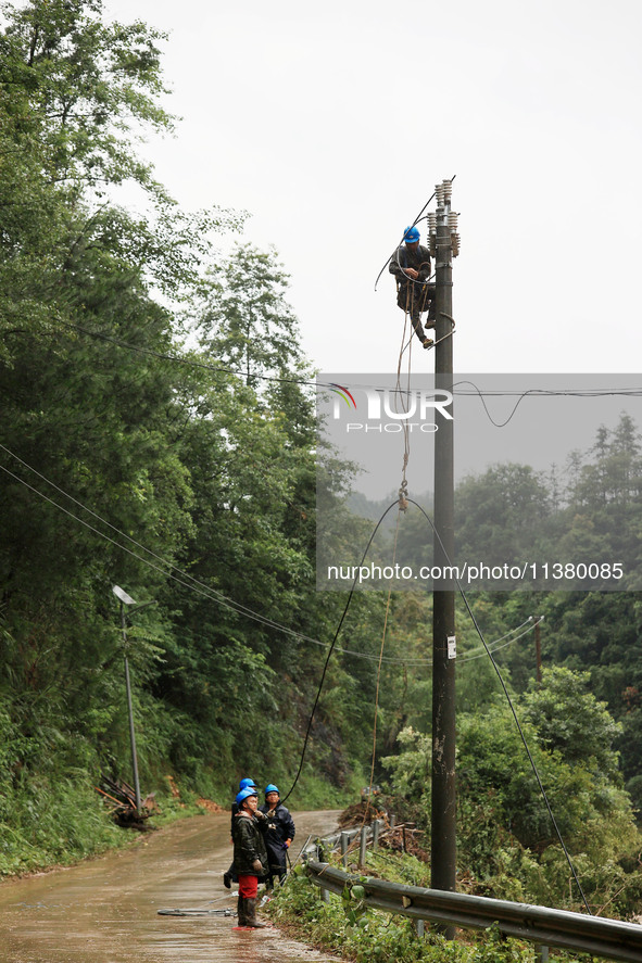 Electric power workers are repairing a power supply line at a pole in Si'an village, Rongan county, Liuzhou city, South China's Guangxi Zhua...