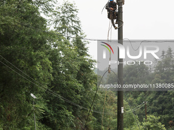 Electric power workers are repairing a power supply line at a pole in Si'an village, Rongan county, Liuzhou city, South China's Guangxi Zhua...