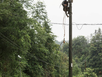 Electric power workers are repairing a power supply line at a pole in Si'an village, Rongan county, Liuzhou city, South China's Guangxi Zhua...