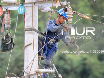 Electric power workers are carrying out repair work after a flood in Si'an village, Rongan County, Liuzhou city, South China's Guangxi Zhuan...