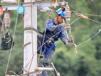 Electric power workers are carrying out repair work after a flood in Si'an village, Rongan County, Liuzhou city, South China's Guangxi Zhuan...