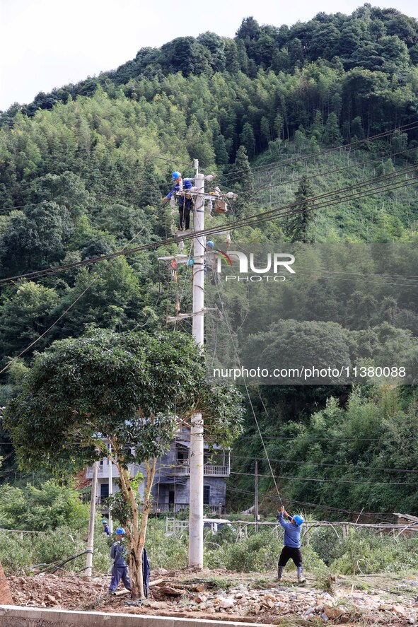 Electric power workers are carrying out repair work after a flood in Si'an village, Rongan County, Liuzhou city, South China's Guangxi Zhuan...