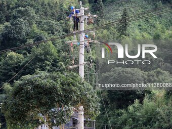 Electric power workers are carrying out repair work after a flood in Si'an village, Rongan County, Liuzhou city, South China's Guangxi Zhuan...