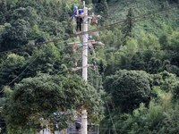 Electric power workers are carrying out repair work after a flood in Si'an village, Rongan County, Liuzhou city, South China's Guangxi Zhuan...