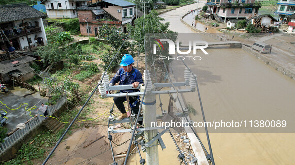 Electric power workers are repairing a power supply line at a pole in Si'an village, Rongan county, Liuzhou city, South China's Guangxi Zhua...