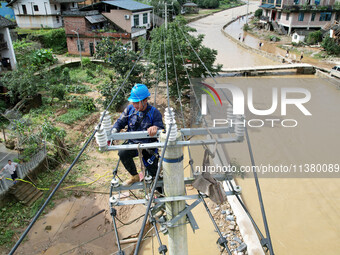 Electric power workers are repairing a power supply line at a pole in Si'an village, Rongan county, Liuzhou city, South China's Guangxi Zhua...