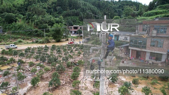 Electric power workers are repairing a power supply line at a pole in Si'an village, Rongan county, Liuzhou city, South China's Guangxi Zhua...