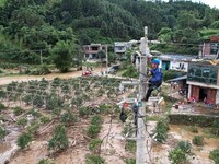 Electric power workers are repairing a power supply line at a pole in Si'an village, Rongan county, Liuzhou city, South China's Guangxi Zhua...