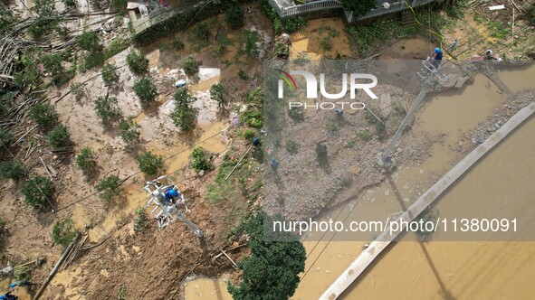 Electric power workers are repairing a power supply line at a pole in Si'an village, Rongan county, Liuzhou city, South China's Guangxi Zhua...