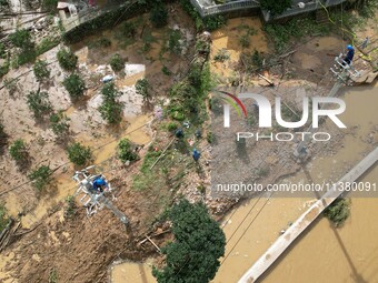 Electric power workers are repairing a power supply line at a pole in Si'an village, Rongan county, Liuzhou city, South China's Guangxi Zhua...