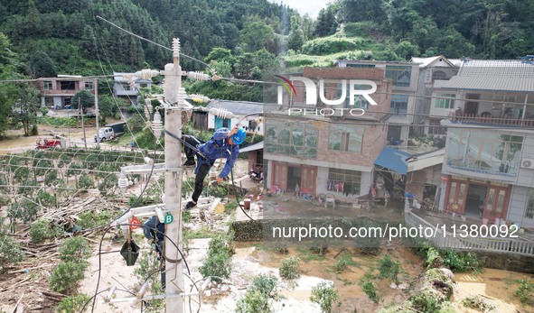 Electric power workers are repairing a power supply line at a pole in Si'an village, Rongan county, Liuzhou city, South China's Guangxi Zhua...