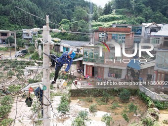 Electric power workers are repairing a power supply line at a pole in Si'an village, Rongan county, Liuzhou city, South China's Guangxi Zhua...