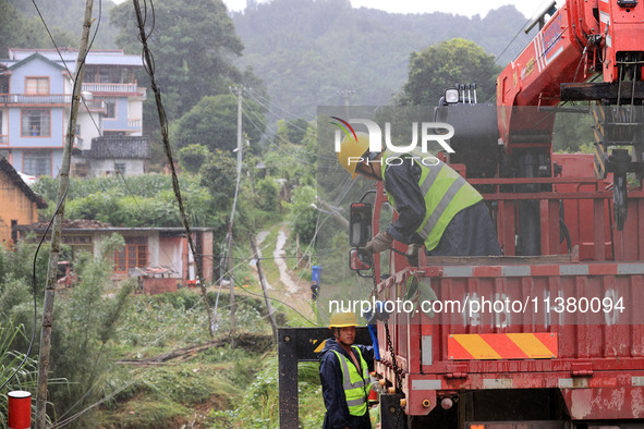 Power emergency repair personnel are unloading emergency repair materials in the rain at Si'an Village, Rongan County, Liuzhou City, Guangxi...