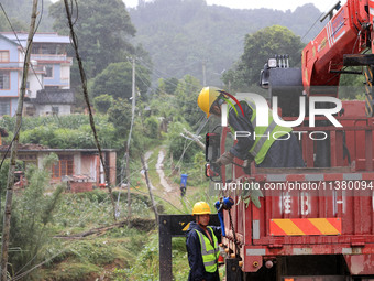 Power emergency repair personnel are unloading emergency repair materials in the rain at Si'an Village, Rongan County, Liuzhou City, Guangxi...