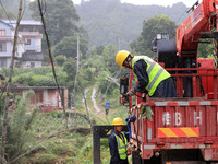 Power emergency repair personnel are unloading emergency repair materials in the rain at Si'an Village, Rongan County, Liuzhou City, Guangxi...