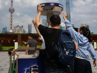 People are trying to reach the mist sprinkler during the heatwave at the Bund in Shanghai, China, on July 3, 2024. (