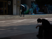 A man is resting on the bench during the heatwave on Nanjing Road in Shanghai, China, on July 3, 2024. (