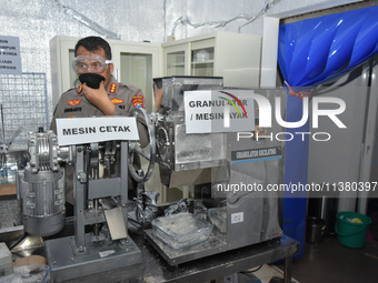 Police officers are showing production equipment at a clandestine laboratory of a Chinese network that is producing Gloria tobacco, ecstasy...