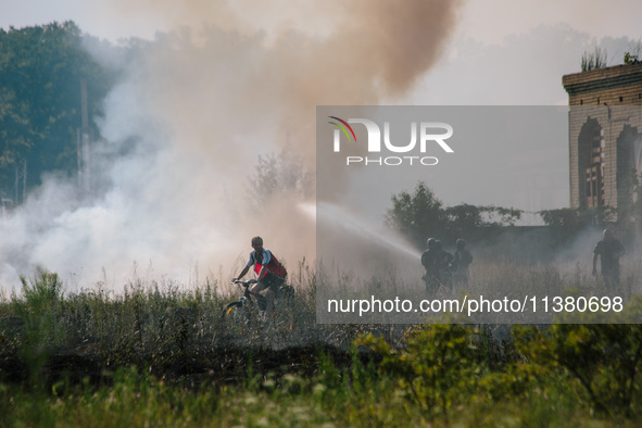 Firefighters are putting out a fire in a field, in Kharkiv, Ukraine, on July 3, 2024. On the afternoon of July 3, 2024, Russia launched an a...