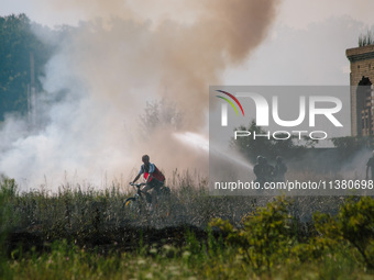 Firefighters are putting out a fire in a field, in Kharkiv, Ukraine, on July 3, 2024. On the afternoon of July 3, 2024, Russia launched an a...