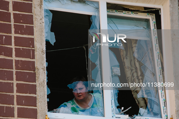 A woman is standing in a window broken by an airstrike, in Kharkiv, Ukraine, on July 3, 2024. On the afternoon of July 3, 2024, Russia launc...