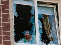 A woman is standing in a window broken by an airstrike, in Kharkiv, Ukraine, on July 3, 2024. On the afternoon of July 3, 2024, Russia launc...