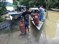 Villagers are shifting liquefied petroleum gas (LPG) cylinders to a safer place in Morigaon District of Assam, India, on July 3, 2024. (