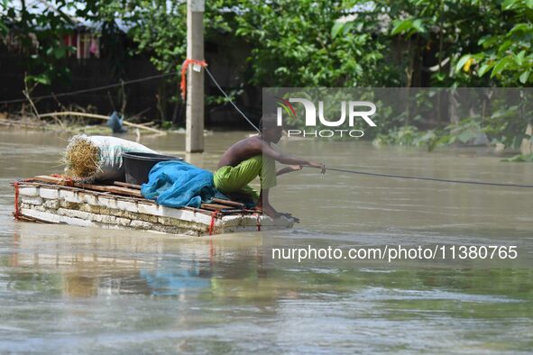 A boy is using a raft in the flood-affected Mayong village in Morigaon district, Assam, India, on July 3, 2024. 