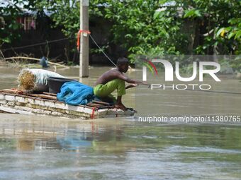 A boy is using a raft in the flood-affected Mayong village in Morigaon district, Assam, India, on July 3, 2024. (