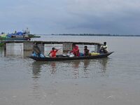 Indian villagers are traveling on a boat through a flooded village in Morigaon District of Assam, India, on July 3, 2024. (