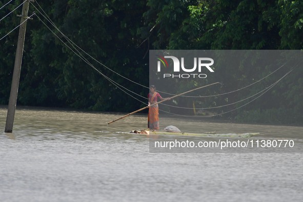 A woman is riding a banana raft in the flood-affected Mayong village in Morigaon district in Assam, India, on July 3, 2024. 