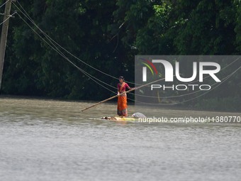 A woman is riding a banana raft in the flood-affected Mayong village in Morigaon district in Assam, India, on July 3, 2024. (