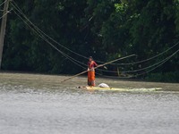 A woman is riding a banana raft in the flood-affected Mayong village in Morigaon district in Assam, India, on July 3, 2024. (