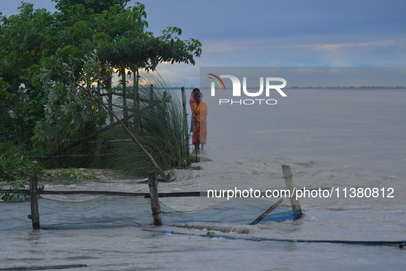 Women are standing near a damaged road after heavy rains in Bhurbandha village in Nagaon district of Assam, India, on July 2, 2024. 