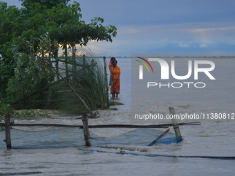 Women are standing near a damaged road after heavy rains in Bhurbandha village in Nagaon district of Assam, India, on July 2, 2024. (