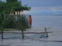 Women are standing near a damaged road after heavy rains in Bhurbandha village in Nagaon district of Assam, India, on July 2, 2024. (