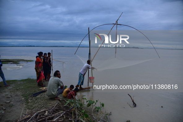 A villager is fishing on flood water after heavy rains in Bhurbandha village in Nagaon district of Assam, India, on July 2, 2024. 