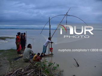 A villager is fishing on flood water after heavy rains in Bhurbandha village in Nagaon district of Assam, India, on July 2, 2024. (