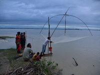 A villager is fishing on flood water after heavy rains in Bhurbandha village in Nagaon district of Assam, India, on July 2, 2024. (