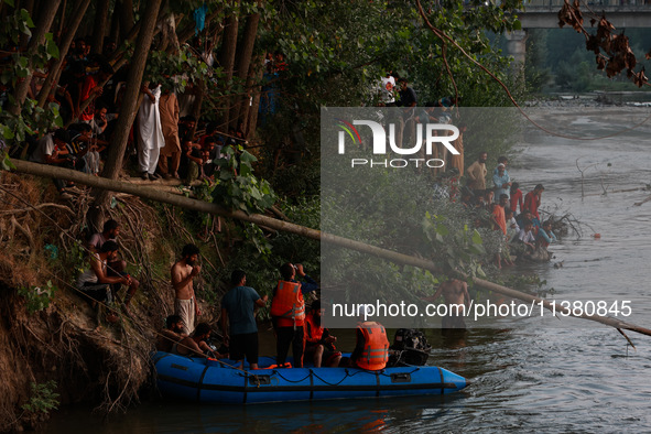 Villagers are watching as SDRF is launching an operation to trace the body of a young man who drowned in Nalla Puhroo while taking a bath on...