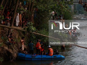 Villagers are watching as SDRF is launching an operation to trace the body of a young man who drowned in Nalla Puhroo while taking a bath on...