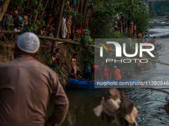 Villagers are watching as SDRF is launching an operation to trace the body of a young man who drowned in Nalla Puhroo while taking a bath on...