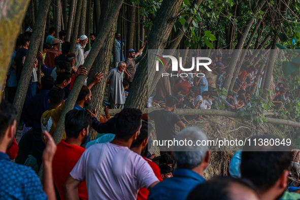 Villagers are watching as SDRF is launching an operation to trace the body of a young man who drowned in Nalla Puhroo while taking a bath on...